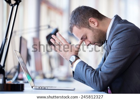 frustrated young business man working on laptop computer at office Royalty-Free Stock Photo #245812327