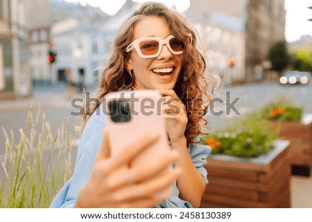 Cheerful female tourist clicking selfie pictures via cellphone front camera. Lifestyle, travel, tourism, active life.