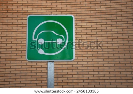 Green electric charging parking sign for zero-emission electric vehicles.
