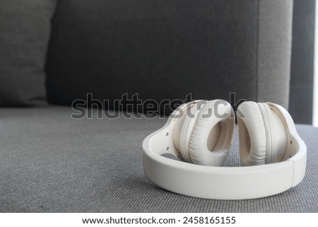 White headphones lying around after use. Entertainment concept of listening to music.
