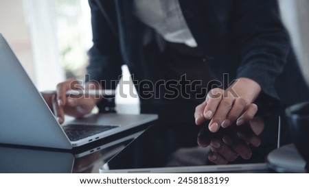 Businesswoman using digital tablet and laptop computer on office table. Business woman busy working on digital tablet and typing on laptop computer, searching business data, surfing the internet 