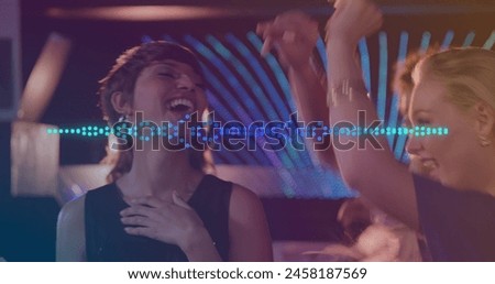Image of spots moving over smiling caucasian group of friends dancing at party. dance day and celebration concept digitally generated image.