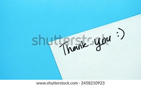 Handwritten words of thank you on a blue background. copy space