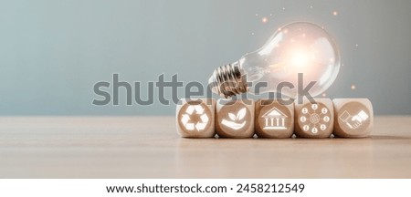 ESG, Environment social governance investment business concept, Wooden block and light bulb on desk with environment social governance icon on virtual screen.