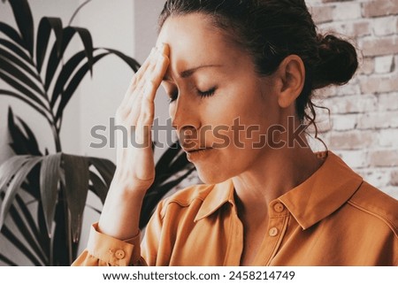 Tired stressed businesswoman feeling strong headache massaging temples exhausted from overwork, fatigued overwhelmed lady executive worker suffering from pain in head or chronic Royalty-Free Stock Photo #2458214749