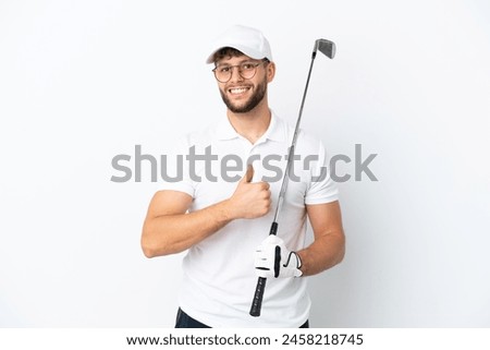 Handsome young man playing golf  isolated on white background giving a thumbs up gesture