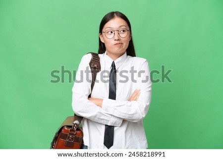 Young Asian business woman over isolated background making doubts gesture while lifting the shoulders