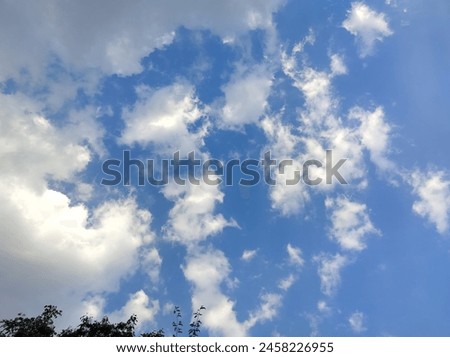 Picture of a bright blue sky with small clouds like stars decorating the sky
