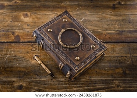 Aged leather book with the Ouroboros symbol on the front cover plate