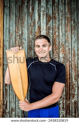 Portrat of young canoeist holding paddle. Concept of canoeing as dynamic and adventurous sport. Royalty-Free Stock Photo #2458310819