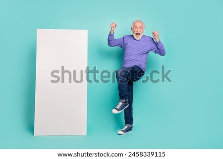 Full body photo of excited crazy man raise fists celebrate success empty space huge telephone isolated on teal color background