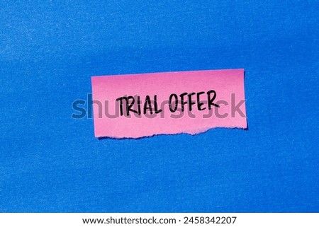 Trial offer words written on ripped pink paper with blue background. Conceptual trial offer symbol. Copy space.