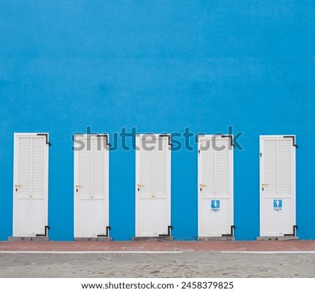 Changing cabins on the beach of a bathhouse with signs on it.taly, Cesenatico. Empty space on top Royalty-Free Stock Photo #2458379825