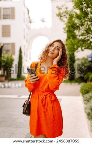 Woman traveler with a mobile phone. Happy Woman texting, browsing, using her smartphone on a warm sunny day. Positive emotions. Apps.