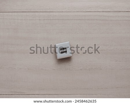 
square magnet with equivalent icon. on wooden background. concept of equal