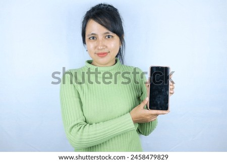 Young beautiful asian woman holding blank screen smart phone on white background