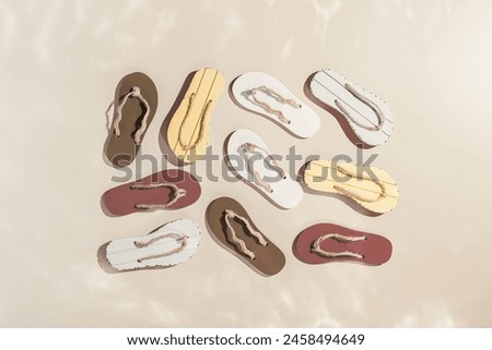 Female summer shoes, set sandals as creative square  pattern with hard shadow, beige brown white flip flops on beige gradient color background. Aesthetic trend summer fashion concept, life style photo