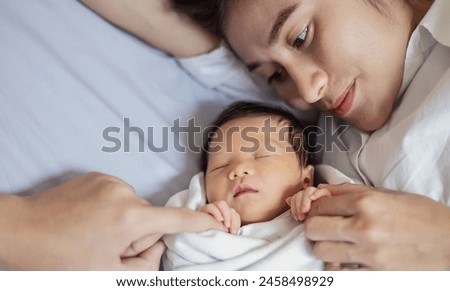 Close up portrait of beautiful young asian caucasian mother day girl kissing healthy newborn baby sleep in bed with copy space. Healthcare and medical love asia woman lifestyle mother's day banner