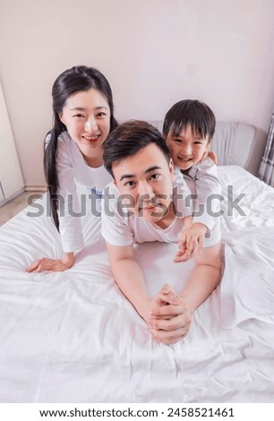 A family of three in the bed in the bedroom