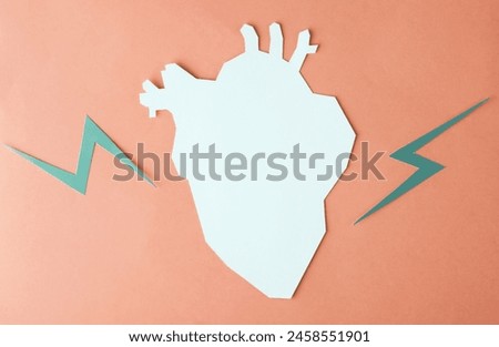 Heart attack. Paper cut anatomical heart with lightning on red background