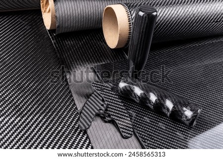 lightweight carbon fiber tuning parts and CFK sheet on composite  raw material cloth.  automotive and car racing  industry and high tech background.