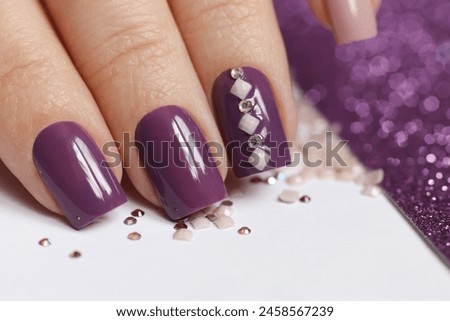 Lilac manicure on short nails with rhinestones. Royalty-Free Stock Photo #2458567239
