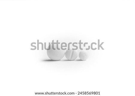 Three white generic pills next to each other on white background.