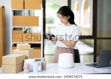 Young women taking photo of product with digital camera for post to sell online on the Internet and preparing pack product box. Selling online ideas concept
