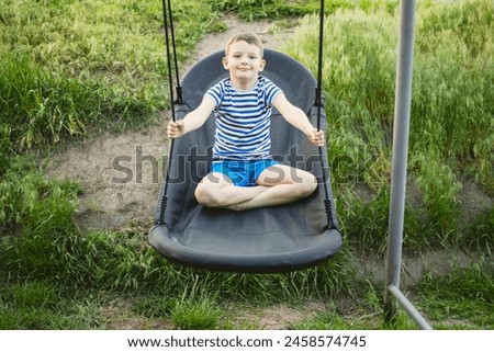 Boy on Swing in Summer Outdoors.