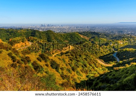 Verdant hills and winding trails of Griffith Park, with the iconic skyline of Los Angeles. Tranquility and the vibrant canvas of the City on Angeles.