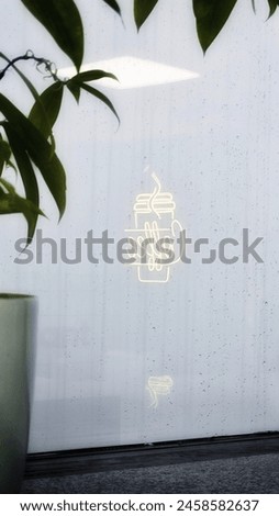 Indulge in the simplicity of coffee culture with this captivating image. A subtle reflection of a coffee sign dances on a sleek surface, juxtaposed against a minimalist photo of a coffee. Royalty-Free Stock Photo #2458582637