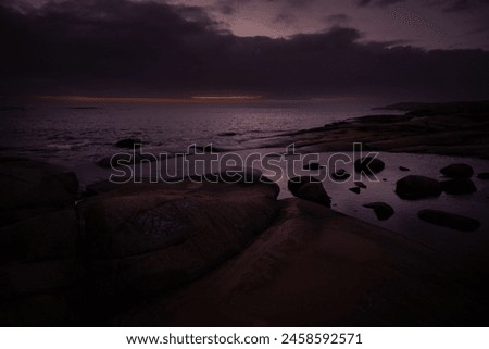 Sunset colors at the horizon, cloudy skies, rainy weather and troubled sea over the Skagerrak ocean. Royalty-Free Stock Photo #2458592571