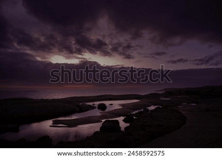 Sunset colors at the horizon, cloudy skies, rainy weather and troubled sea over the Skagerrak ocean. Royalty-Free Stock Photo #2458592575