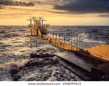 Blackrock diving board in Galway city, Ireland. Popular city landmark by the ocean with beautiful viewpoint on top. Travel and tourist hotspot. Sport and entertainment. Dramatic sunrise light.