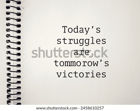Inspirational motivational quote - today's struggles are tomorrow's victories text on notebook background. Stock photo.