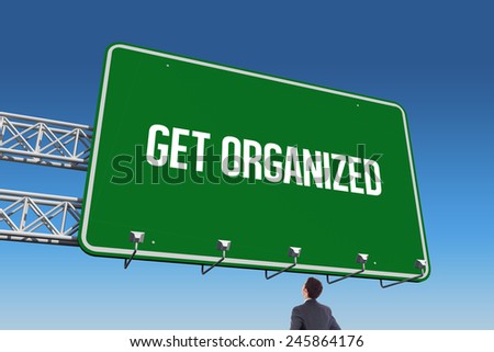 The word get organized and businessman standing with hands on hips against blue sky