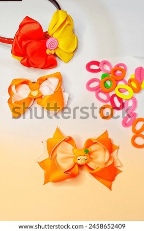cute and colorful girls accessories. orange hair clips decorated with cute clay, headbands with red and yellow ribbons, and colorful hair elastics.