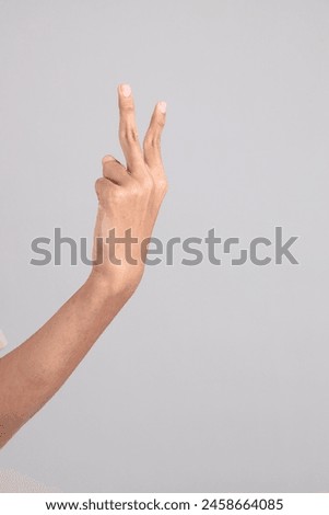 The hand of Young South Asian teen with the casual clothes standing on the gray background, with gesture of Counting number or calculation