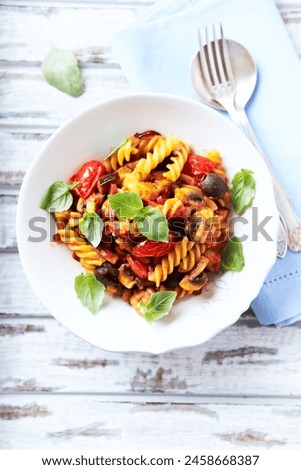 Pasta with cherry tomatoes, and olives. Bright wooden background. Top view. Close up.	Copy space.