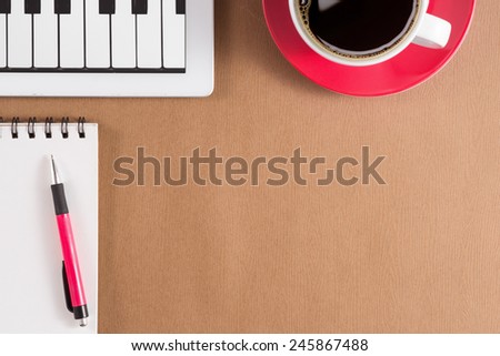 Digital tablet computer with sticky note paper and cup of coffee on old wooden desk. Simple workspace or coffee break with web surfing. View from above