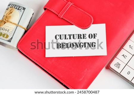 Culture of belonging symbol on a business card on a business notebook near money and a calculator on a white background