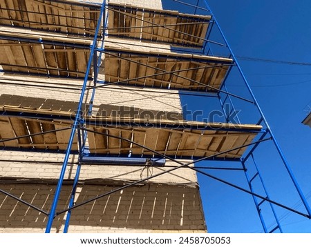 Scaffolding frame construction assembled around buildings. Local home renovation concept. Mobile phone photo, not AI