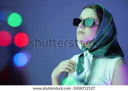 Portrait of beautiful young woman with sunglasses on color background with neon lights. Bokeh effect