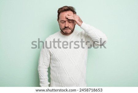 middle age handsome man looking stressed, tired and frustrated, drying sweat off forehead, feeling hopeless and exhausted