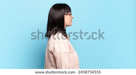 plus size pretty woman on profile view looking to copy space ahead, thinking, imagining or daydreaming