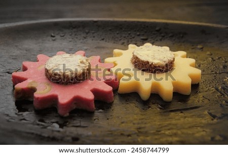Concept, compatible and balanced food products for humans. Cheese and ham cuts in the form of gear wheels are connected together, bread greased with butter is inserted into the cheese and sausage, sim
