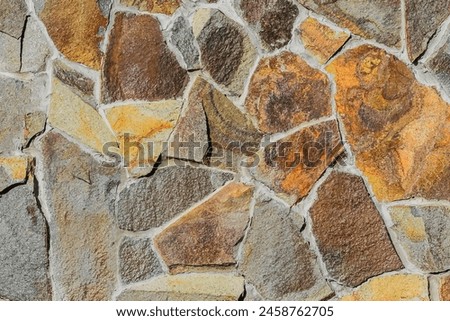 It is close up view of multicolored stone wall.  It's photo of mosaic stones in wall. This is colorful texture for the designer. 