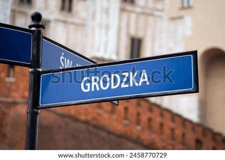 Grodzka street name sign in the Old Town district of Krakow, Poland. Information direction signage plate on a signpost in Kraków. One of the oldest streets of Cracow.