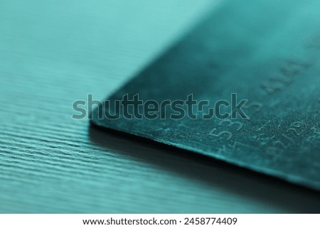 One credit card on turquoise background, closeup Royalty-Free Stock Photo #2458774409