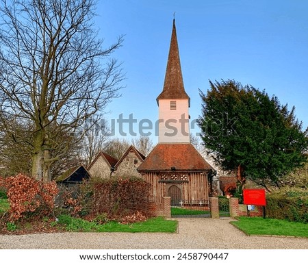 The historic All Saints Church in the picturesque village of Stock, Essex, UK against a clear blue sky background.